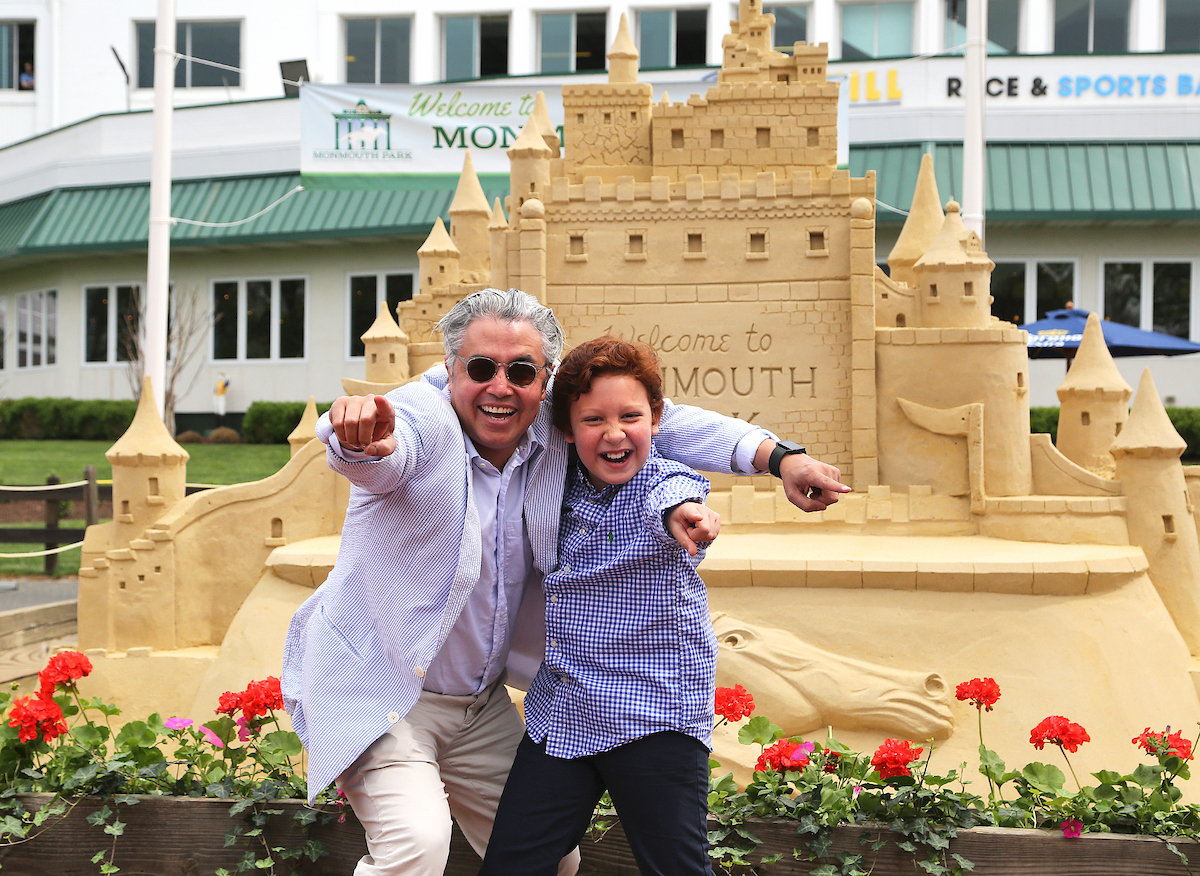 father and son by sand castle