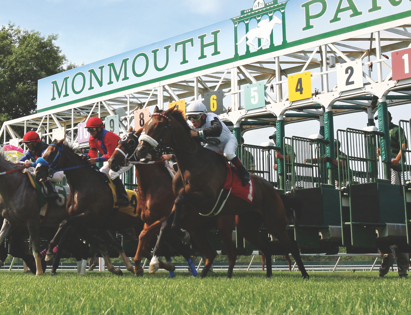 Horses racing in front of Monmouth Park sign